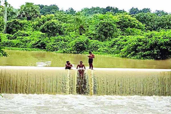 ভারি বর্ষণে নওগাঁর নিয়ামতপুর এলজিইডির বাঁধের ওপর দিয়ে প্রবাহিত হচ্ছে পানি। সৃষ্টি হয়েছে নয়নাভিরাম জলপ্রপাত