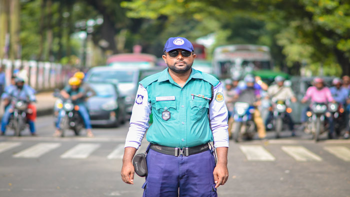 রাজধানীতে দায়িত্বপালনরত ট্রাফিক পুলিশ। ছবি তুলেছেনঃ নুরে আলম