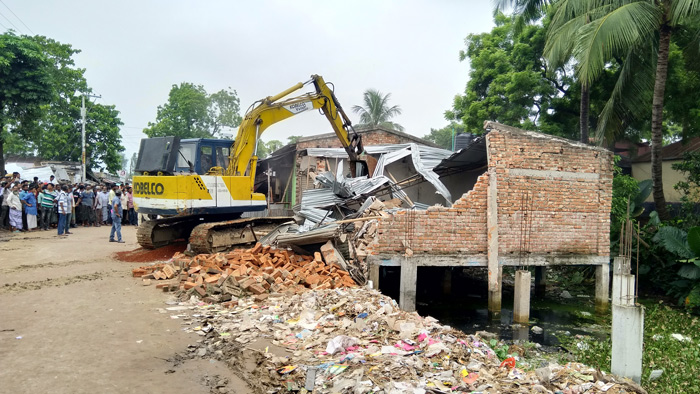 রানীনগরে রেলওয়ের জমিতে থাকা অবৈধ স্থাপনা স্কেবেটার মেশিন দিয়ে গুড়িয়ে দেয়া হয়। ছবি: একুশে টেলিভিশন