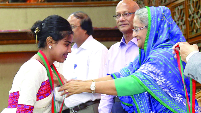 প্রধানমন্ত্রী শেখ হাসিনার হাত থেকে স্বর্ণপদক গ্রহণকালে লেখক