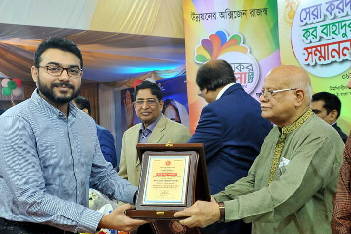 অর্থমন্ত্রী আবুল মাল আবদুল মুহিতের কাছ থেকে দেশসেরা তরুণ করদাতার পদক নিচ্ছেন সৈয়দ মোহাম্মদ তানভীর